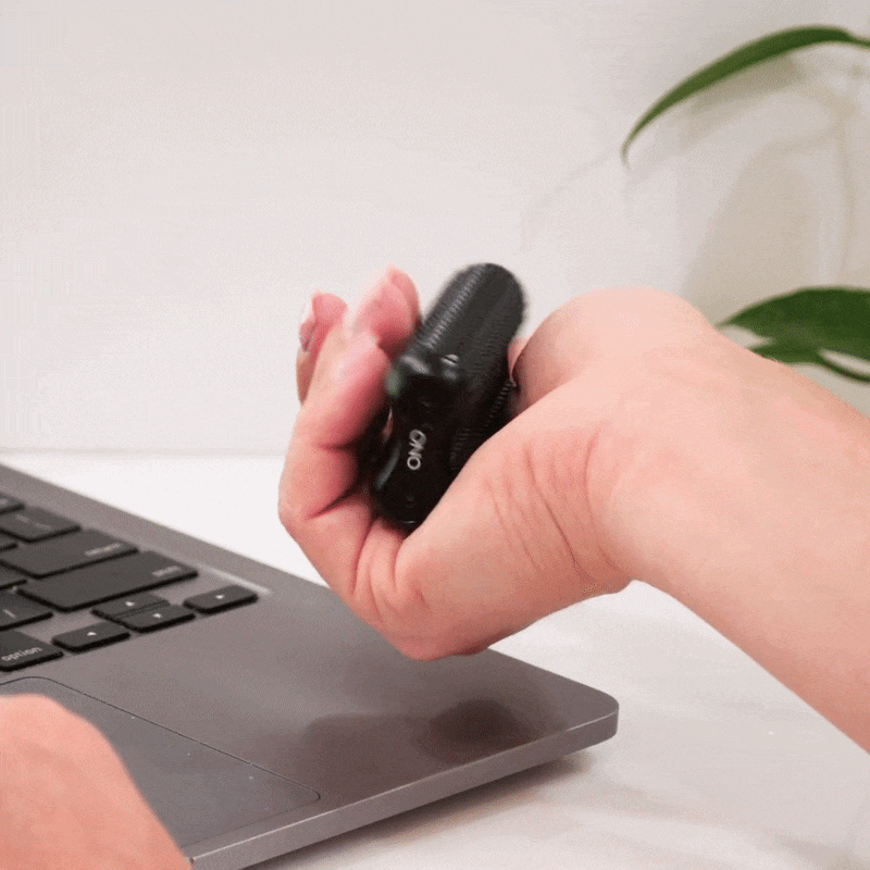 eam_Black Acupressure_all | Hand holding black ONO acupressure roller massager over laptop keyboard