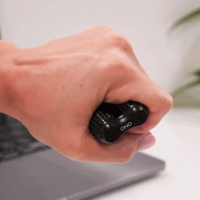 eam_Black Acupressure_all | Black ONO acupressure hand massager roller held in palm, lifestyle product shot